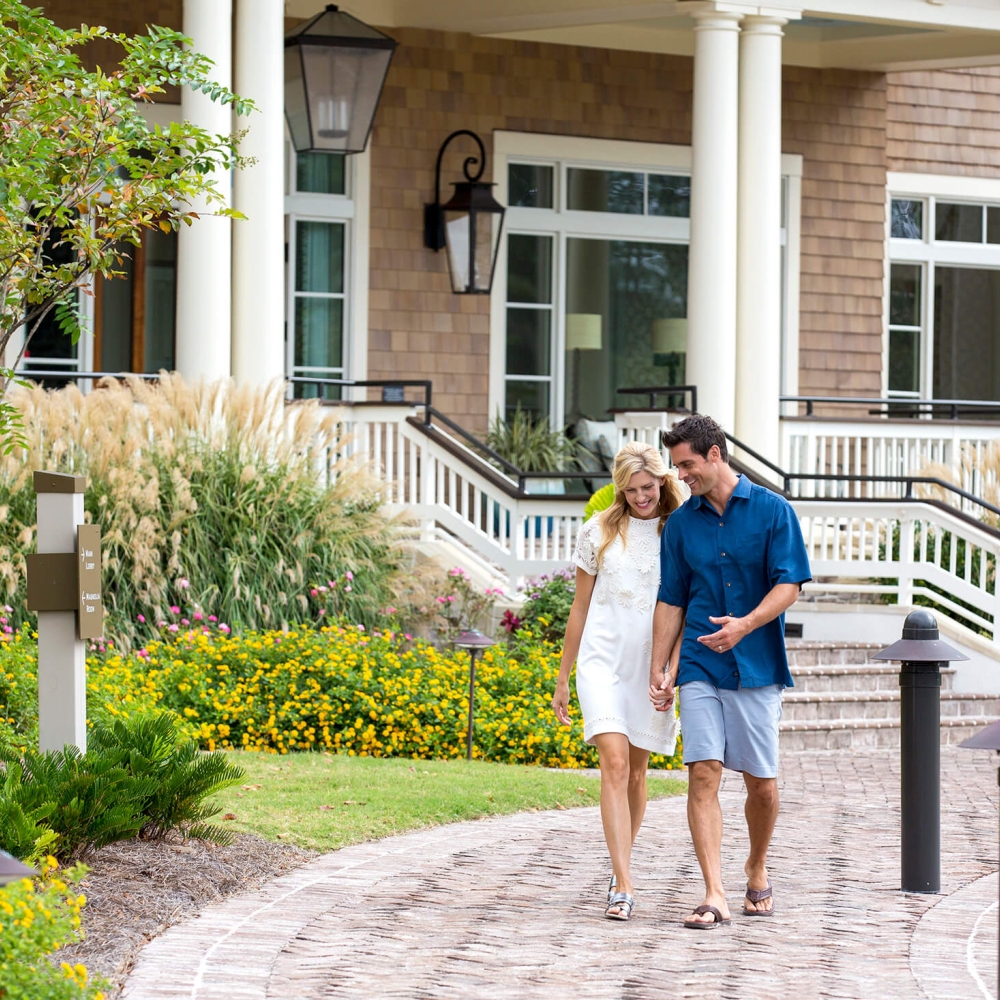 Man and women walking with the golf club in the background 