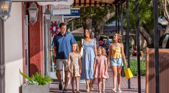 Family walking on the sidewalk with shopping bags 